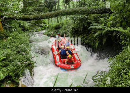 Pangalengan, Bandung-Indonésie décembre 2022 : Un groupe d'hommes et de femmes font du rafting sur la rivière, du sport extrême et amusant. Groupe de personnes sport nautique r Banque D'Images