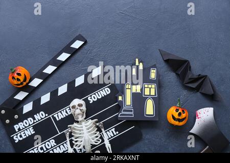 Clapperboard avec décor d'Halloween différent sur fond bleu grunge Banque D'Images