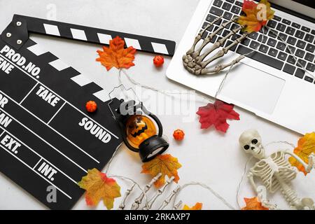 Clapperboard avec ordinateur portable et décor d'Halloween différent sur fond blanc Banque D'Images