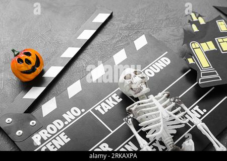 Clapperboard avec décor d'Halloween différent sur fond bleu grunge Banque D'Images