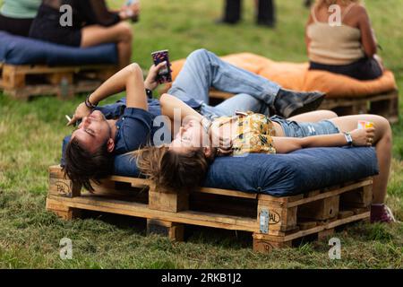 Les festivaliers se reposent pendant le festival Rock en Seine 2023. Le premier jour de la 20e édition du festival de musique français Rock en Seine a réuni environ 40 000 personnes qui ont assisté au concert de l’artiste américaine Billie Eilish, au domaine National de Saint-Cloud. Banque D'Images