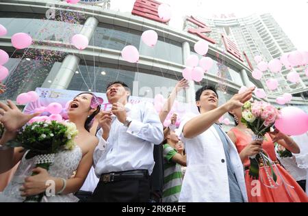 Bildnummer: 54524758  Datum: 10.10.2010  Copyright: imago/Xinhua (101010) -- NANNING, Oct. 10, 2010 (Xinhua) -- Newly-wed couples release balloons on a group wedding in Nanning, south China s Guangxi Zhuang Autonomous Region, Oct. 10, 2010. Numerous young lovers across China got married on Oct. 10, 2010, or 10/10/10, hoping that the triple 10 day will bring them good luck. In Chinese culture, many believed that three 10 s in a row means perfection.(Xinhua/Liu Jun) (xzj) CHINA-LIFESTYLE-MARRIAGE-OCTOBER 10 (CN) PUBLICATIONxNOTxINxCHN Gesellschaft Hochzeit Heirat kbdig xkg 2010 quer premiumd Stock Photo