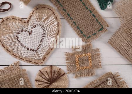 Composition de pose à plat avec des morceaux de toile de jute sur la table en bois blanc Banque D'Images