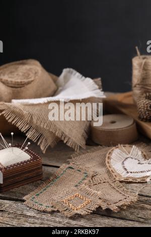 Morceaux de toile de jute et coussin sur table en bois, espace pour le texte Banque D'Images