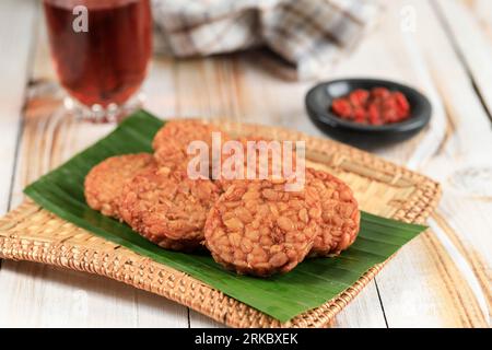 Tempeh rond Goreng ou tempe frit servi avec Sambal et thé chaud. Banque D'Images
