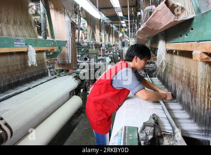 Bildnummer : 54625131 Datum : 09.11.2010 Copyright : imago/Xinhua (101110) -- SHAOXING, 10 novembre 2010 (Xinhua) -- Un ouvrier travaille chez Anda textile Co., Ltd. Dans la ville de Zhuji, province de Zhejiang dans l'est de la Chine, 9 novembre 2010. Les exportateurs de textiles dans la province du Zhejiang, une zone importante d'exportation de texitles en Chine, peinent à survivre dans un contexte de hausse des matières premières. Nous devons mettre fin à la production après avoir terminé cette commande. Le fil acheté en août et septembre sera hors d'usage, mais le prix de la matière première a trop augmenté. Dit Zhang vous an, patron de Anda textile Co., Ltd qui produit des sati de qualité supérieure Banque D'Images