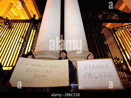 Bildnummer : 54667423 Datum : 22.11.2010 Copyright : imago/Xinhua (101122) -- DUBLIN, 22 novembre 2010 (Xinhua) -- des manifestants brandissent des pancartes contre le parti au pouvoir Fianna Fail devant les bâtiments du gouvernement à Dublin, Irlande, le 22 novembre 2010. Cowen a déclaré lundi qu'il ne démissionnait pas parce qu'il est déterminé à adopter un budget d'urgence de quatre ans. Le Parti vert irlandais, membre du gouvernement de coalition, a appelé lundi tôt à dissoudre le Parlement en janvier pour une élection anticipée, après que le gouvernement a confirmé accepter un plan de sauvetage massif UE-FMI pour la crise de la dette du pays. (Xinhua/Z Banque D'Images