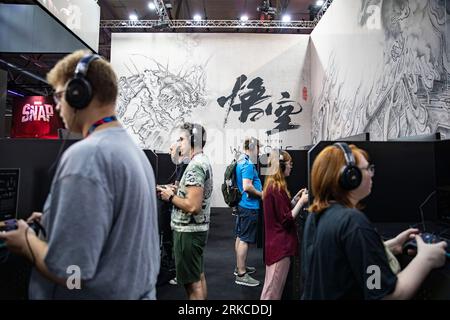 Cologne, Allemagne. 23 août 2023. Les gens essaient des jeux sur le stand de la science des jeux lors de la gamescom 2023 à Cologne, Allemagne, le 23 août 2023. L'édition 2023 du salon international des jeux informatiques et vidéo gamescom s'est ouverte mercredi à Cologne, dans l'ouest de l'Allemagne. Les entreprises chinoises ont exposé leurs produits sur le salon. Selon le Koelnmesse, organisateur de l'événement d'une semaine, la gamescom est le plus grand salon mondial des jeux vidéo et informatiques en termes d'espace et de visiteurs. Crédit : Zhang Fan/Xinhua/Alamy Live News Banque D'Images