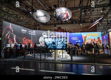 Cologne, Allemagne. 23 août 2023. Les gens visitent le stand de NetEase lors de la gamescom 2023 à Cologne, Allemagne, le 23 août 2023. L'édition 2023 du salon international des jeux informatiques et vidéo gamescom s'est ouverte mercredi à Cologne, dans l'ouest de l'Allemagne. Les entreprises chinoises ont exposé leurs produits sur le salon. Selon le Koelnmesse, organisateur de l'événement d'une semaine, la gamescom est le plus grand salon mondial des jeux vidéo et informatiques en termes d'espace et de visiteurs. Crédit : Zhang Fan/Xinhua/Alamy Live News Banque D'Images