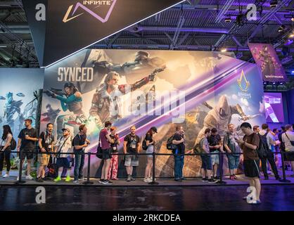 Cologne, Allemagne. 23 août 2023. Les gens font la queue pour essayer des jeux sur le stand de Tencent lors de la gamescom 2023 à Cologne, en Allemagne, le 23 août 2023. L'édition 2023 du salon international des jeux informatiques et vidéo gamescom s'est ouverte mercredi à Cologne, dans l'ouest de l'Allemagne. Les entreprises chinoises ont exposé leurs produits sur le salon. Selon le Koelnmesse, organisateur de l'événement d'une semaine, la gamescom est le plus grand salon mondial des jeux vidéo et informatiques en termes d'espace et de visiteurs. Crédit : Zhang Fan/Xinhua/Alamy Live News Banque D'Images