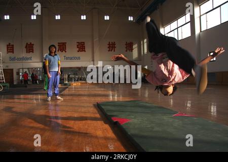 Bildnummer : 54769811 Datum : 23.12.2010 Copyright : imago/Xinhua (101225) -- WUQIAO, 25 décembre 2010 (Xinhua) -- quinze ans Eint Chaw Chaw Thu (L) du Myanmar wathches, douze ans Nay Chi su su su Lat, pratiquant des somersaults à l'école d'art acrobatique de Wuqiao, province de Wuqiao, 23 décembre 2010. Dans le cadre des programmes d’échange parrainés par le gouvernement chinois, vingt-quatre étudiants de cinq pays africains et asiatiques, dont l’Égypte, le Nigéria, le Libéria, Maurice et le Myanmar, a commencé en novembre leur formation d'un an d'acrobatie à Wuqiao Acrobatie Arts School, une vocation Banque D'Images