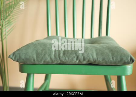 oreiller sur une chaise en bois vert dans une chambre Banque D'Images