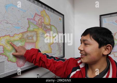 Bildnummer : 54874483 Datum : 02.02.2011 Copyright : imago/Xinhua SHANGHAI, 2 février 2011 (Xinhua) -- Monitor Nureli pointe la position de sa ville natale Kaxgar, dans la région autonome ouïgour du Xinjiang du nord-ouest de la Chine, sur une carte du lycée Songjiang n ° 1 à Shanghai, dans l'est de la Chine, le 2 février 2011. Les responsables du comité de Shanghai du Parti communiste chinois sont venus mercredi à la classe du Xinjiang et ont donné leurs salutations de la fête du Printemps aux étudiants. Le lycée Songjiang No 1 en septembre 2010 a créé une nouvelle classe recrutant des étudiants du Xinjiang. Il y a eu 86 étudiants qui étudient Banque D'Images