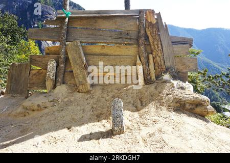 Cibles de tir à l'arc en bois criblé de trous de flèches et panneau en bois rustique le long du sentier de montagne jusqu'au monastère du nid de tigre près de Paro, au Bhoutan Banque D'Images