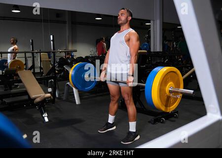 Un homme hispanique fort soulevé de terre dans une salle de gym. Banque D'Images