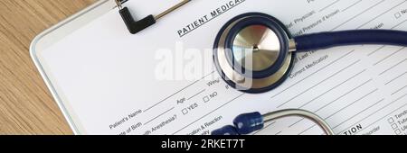 Feuille vierge de la forme des antécédents médicaux du patient avec stéthoscope et pilules, vue du dessus. Banque D'Images