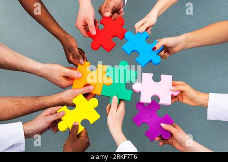 Portrait de l'équipe médicale Problèmes Puzzle coloré contre l'arrière-plan gris Banque D'Images