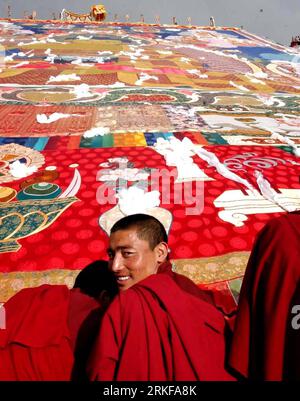 Bildnummer : 55387009 Datum : 27.08.2003 Copyright : imago/Xinhua (110522) -- LHASSA, mai 22, (Xinhua) -- la photo prise le 27 août 2003 montre un moine souriant en assistant à la cérémonie pour déplier une immense peinture de Bouddha Tangka pendant le festival annuel traditionnel Shoton (yaourt) au monastère Zhaibung à la périphérie de Lhassa, capitale de la région autonome du Tibet du sud-ouest de la Chine. Au cours des 60 dernières années, les Tibétains et les autres minorités ethniques vivant dans la région ont conservé leurs vêtements et ornements traditionnels, leur régime alimentaire et leur style de logement, et ont consacré leur cœur et leur âme à leur beli Banque D'Images