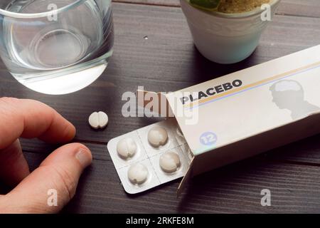 Concept d'effet placebo : l'homme prend une pilule d'une boîte de pilules placebo Banque D'Images