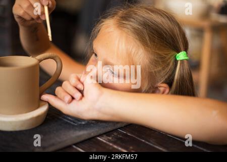 La jeune fille travaille avec de la céramique dans un studio de poterie moderne, à proximité Banque D'Images