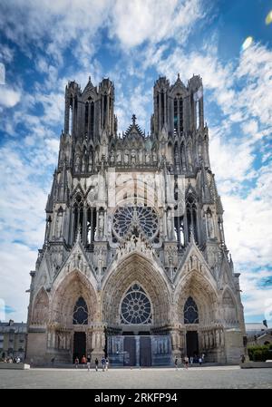 Vue sur la majestueuse cathédrale notre-Dame de Reims, avec ses flèches captivantes et son architecture complexe, illuminée par la douce lumière d'une journée nuageuse Banque D'Images