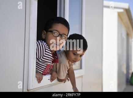 Bildnummer : 55492454 Datum : 18.06.2011 Copyright : imago/Xinhua (110618) -- BENGHAZI, 18 juin 2011 (Xinhua) -- des enfants attendent de la nourriture dans le camp de réfugiés du Croissant-Rouge à Benghazi, Libye, 18 juin 2011. Depuis sa mise en service le 8 mars, le camp, composé de maisons préfabriquées et de 250 tentes, a accueilli 20 000 réfugiés, dont ceux du Ghana, du Tchad, de Somalie et du Nigéria qui vivaient autrefois en Libye. La plupart d'entre eux sont rentrés chez eux. Quelque 380 Libyens vivent encore dans le camp parce que leurs maisons sont dans la zone de combat ou détruites au cours de la bataille. (Xinhua/Dai Xuming) (zw) LIBYE-BENGHAZI- Banque D'Images