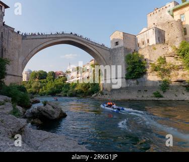 Bateaux rapides sur la rivière Neretva avec des touristes sur Stari Most (vieux pont) à Mostar, Bosnie-Herzégovine, 20 août 2023. Banque D'Images