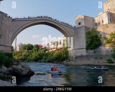 Bateaux rapides sur la rivière Neretva avec des touristes sur Stari Most (vieux pont) et la mosquée Koski-Mehmed Pacha à Mostar, Bosnie-Herzégovine, le 20 août 2023 Banque D'Images