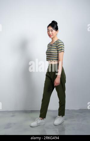 Fille photo pleine longueur taille souriante confiante portant une tenue élégante marchant vers l'avant fond blanc isolé Banque D'Images