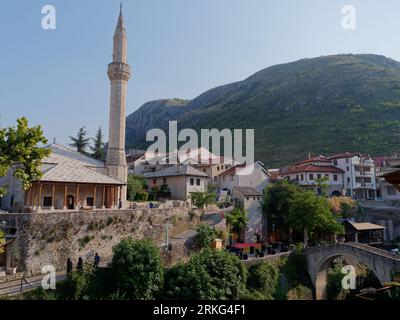 Hadži extérieur de la mosquée Kurt entourée de maisons et de montagnes et d'un pont sur la rivière Nervetva, Mostar, Bosnie-Herzégovine, 21 août 2023. Banque D'Images