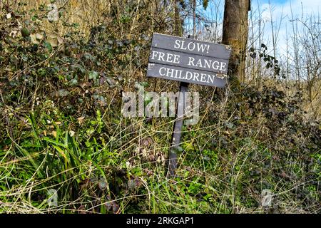 Amusants panneaux routiers « attention aux enfants en liberté » pendant que vous conduisez dans Castle Combe Village Banque D'Images