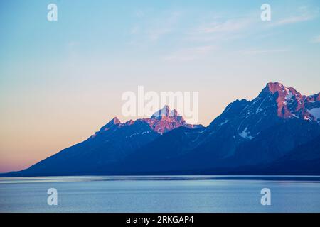 Un paysage pittoresque d'une chaîne de montagnes partiellement submergée dans un plan d'eau, avec ses sommets recouverts d'une couche de neige Banque D'Images