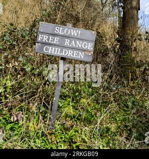 Amusants panneaux routiers « attention aux enfants en liberté » pendant que vous conduisez dans Castle Combe Village Banque D'Images