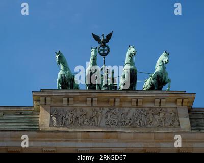 Cette superbe image capture la vue magnifique de quatre majestueux chevaux de bronze perchés au sommet d'un grand bâtiment architectural au cœur de Berlin, Banque D'Images
