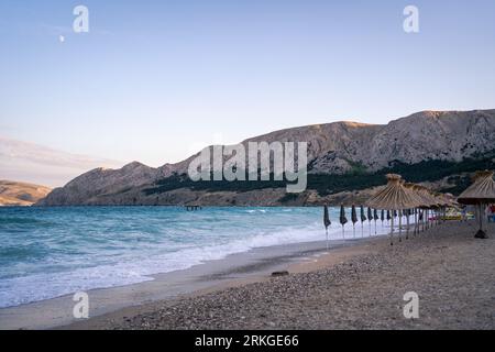 Une scène de plage tranquille sur une île tropicale, avec du sable blanc et des parasols à Beach Baska, Croatie Banque D'Images