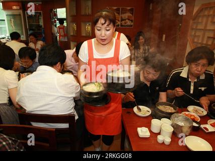 Bildnummer : 55593543 Datum : 14.07.2011 Copyright : imago/Xinhua (110714) -- SÉOUL, 14 juillet 2011 (Xinhua) -- Une serveuse sert du samgyetang (soupe au poulet et au ginseng), un aliment traditionnel coréen qui est censé aider à récupérer de la vigueur dans les chaudes journées d'été, dans un restaurant local à Séoul, Corée du Sud, le 14 juillet 2011. Le samgyetang est une soupe de poulet faite à partir de farcir un jeune poulet avec du riz gluant, du ginseng, des jujubes et de l'ail. (Xinhua/ Park Jin Hee) (yc) CORÉE DU SUD-SÉOUL-SUMMER-FOOD PUBLICATIONxNOTxINxCHN Wirtschaft Gastronomie Südkorea xtm 2011 quer o0 Kellnerin Arbeitswelten Bildnummer 55 Banque D'Images