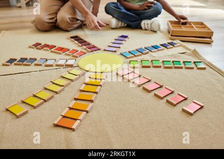 vue recadrée de briques colorées près de garçon afro-américain flou et professeur dans l'école montessori Banque D'Images