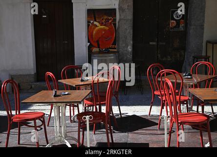 Patio de café local avec chaises de bistro rouge vif sur la via Bordonaro à Cefalù Sicile, Italie. Banque D'Images