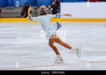 patinage artistique simple, patineuse figurative fille vue arrière en robe bleue Banque D'Images