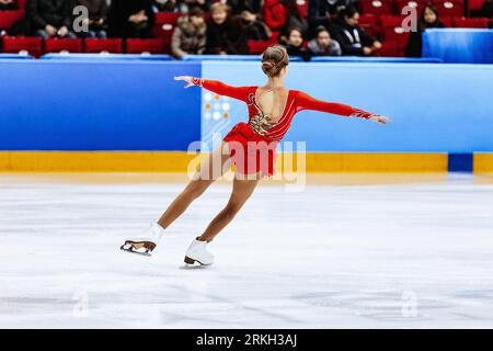 patinage artistique simple, patineuse artistique fille arrière en robe rouge Banque D'Images