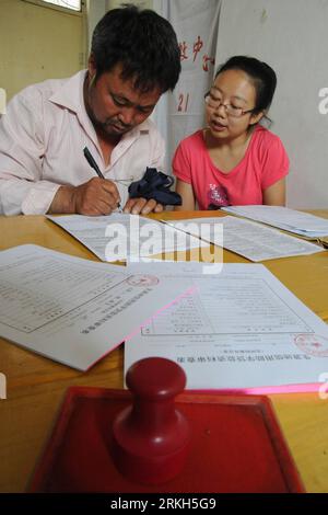 Bildnummer : 55687455 Datum : 09.08.2011 Copyright : imago/Xinhua (110809) -- YUNCHENG, 9 août 2011 (Xinhua) -- Un homme remplit un formulaire de demande pour que sa fille obtienne un prêt étudiant dans un centre de gestion de prêts basé sur l'origine étudiante dans la ville de Yuncheng, province du Shanxi du nord de la Chine, 9 août 2011. Les statistiques publiées récemment par le ministère de l'éducation ont montré qu'en 2010, le montant total des prêts d'État aidés par les étudiants dans les collèges et les universités a atteint 11,357 milliards de yuans (1,76 milliards de dollars américains), avec une augmentation de 21,37 pour cent. Le prêt basé sur l'origine étudiante a pris environ 70 pour cent de Banque D'Images