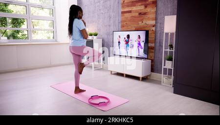 Pratiquer diverses positions de yoga pendant la formation en ligne à la maison Banque D'Images