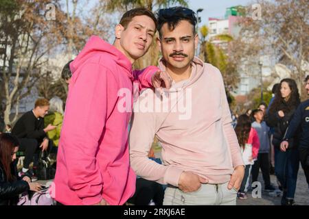 couple masculin de la communauté lgbt en chandail rose, debout ensemble posant et regardant la caméra ensemble marcher à travers le parc le jour ensoleillé au coucher du soleil, peopl Banque D'Images