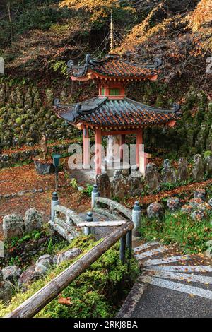 En descendant les marches sur une pagode au temple Otagi Nenbutsu-ji, Arashiyam, Japon. Les jardins du temple sont recouverts de petites statues de pierre appelées rakan Banque D'Images