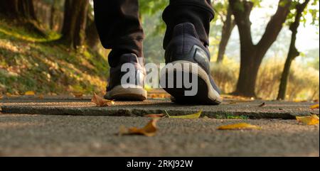 Les pieds d'un homme sur le sentier pédestre le matin, après quelques modifications. Banque D'Images