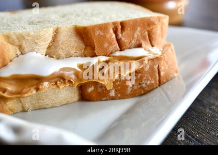 Un sandwich Fluffernutter à base de beurre de cacahuète et de crème de guimauve sur une assiette blanche Banque D'Images