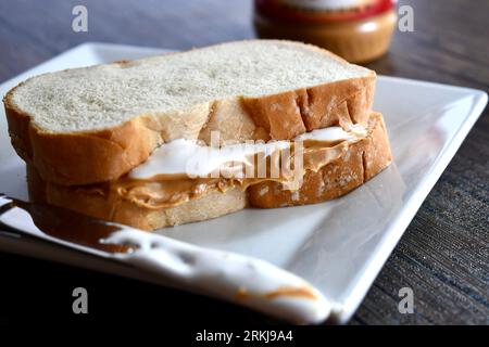 Un sandwich Fluffernutter à base de beurre de cacahuète et de crème de guimauve sur une assiette blanche Banque D'Images