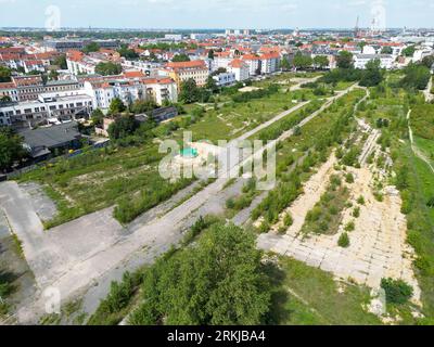 Leipzig, Allemagne. 23 août 2023. Vue sur l'espace ouvert non aménagé derrière la gare Bayerischer Bahnhof au sud de Leipzig. Avec le plan de développement n° 397,1 'Urban Space Bayerischer Bahnhof - Urban Quarter Lößniger Straße', un nouveau quartier doit être créé sur la friche de 36 hectares. Un parc de huit hectares, environ 1 800 appartements, écoles, salles de sport, garderies, des magasins et environ 150 000 mètres carrés d'espace commercial sont prévus dans le quartier des deux côtés de la route du tunnel de la ville. (Photo aérienne avec drone) crédit : Jan Woitas/dpa/Alamy Live News Banque D'Images