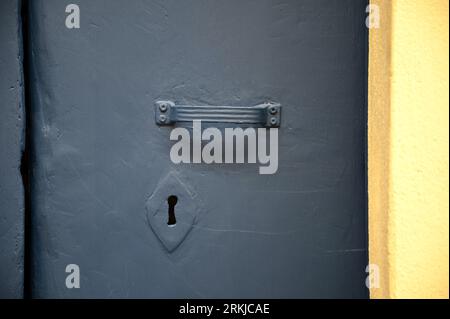 Porte en métal gris antique avec poignée assortie et trou de serrure à Cefalù Sicile, Italie. Banque D'Images
