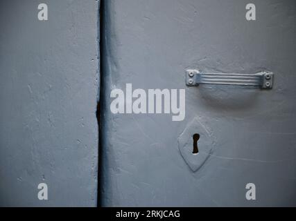 Porte en métal gris antique avec poignée assortie et trou de serrure à Cefalù Sicile, Italie. Banque D'Images